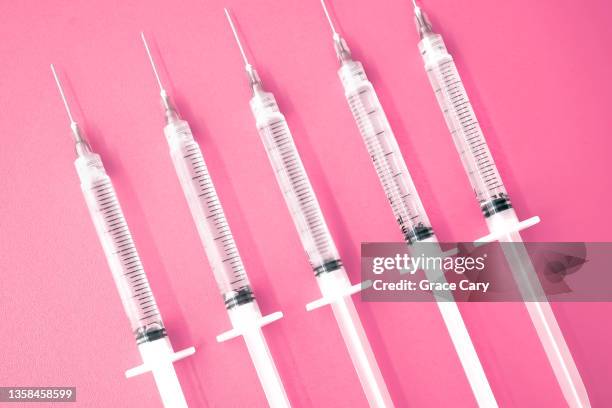 multiple syringes with needles on pink background - injecting bildbanksfoton och bilder