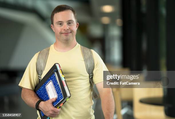 down syndrome student walking to class - verstandelijk gehandicapt stockfoto's en -beelden