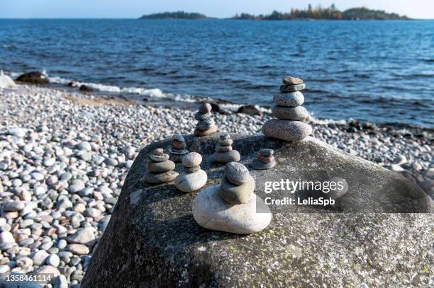 pyramids of stones on the shore of a large lake on a sunny autumn day - lake ladoga stock pictures, royalty-free photos & images
