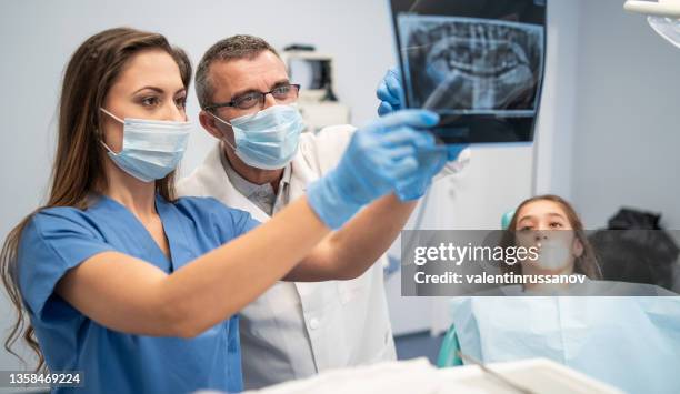 portrait of a dentist holding x-ray image - tandartsassistent stockfoto's en -beelden