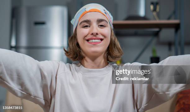 view of a young beautiful female. she is making a video call with her family via her smartphone. - modern family media call stockfoto's en -beelden