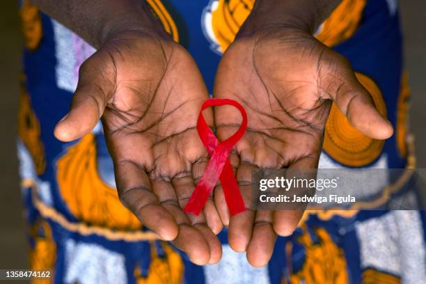 woman holding red ribbon on her palms in burkina faso. - レッドリボン ストックフォトと画像