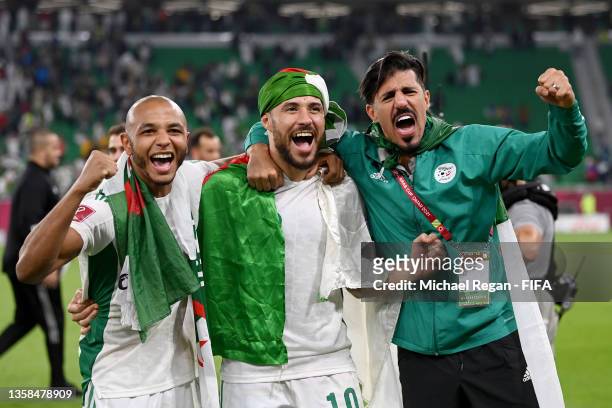 Yacine Brahimi, Mohammed Belaili and Baghdad Bounedjah of Algeria celebrate victory in the FIFA Arab Cup Qatar 2021 Quarter-Final match between...