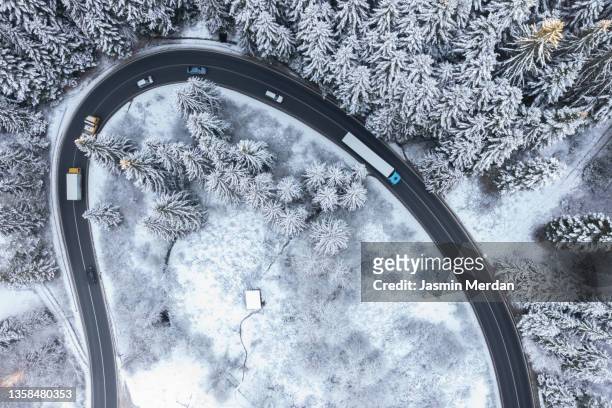 aerial view of winding transport road in winter forest - pick up truck stock-fotos und bilder