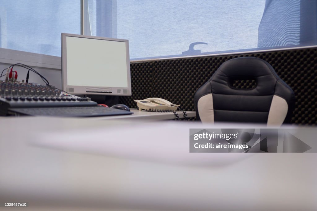 Low angle view of broadcast room with sound recording equipment in a radio station in before her radio show
