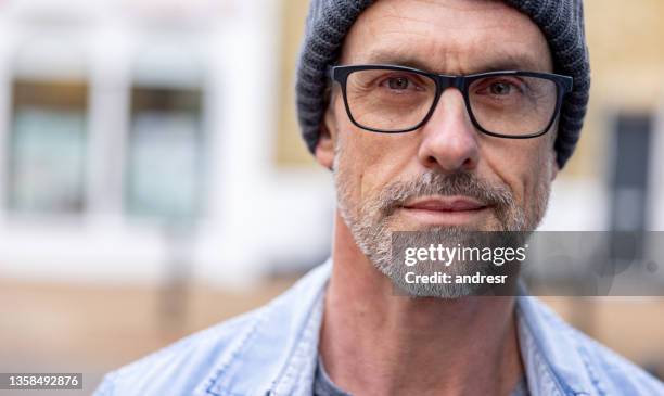 portrait of an adult man on the street wearing glasses and a beanie - portrait of handsome man stock pictures, royalty-free photos & images