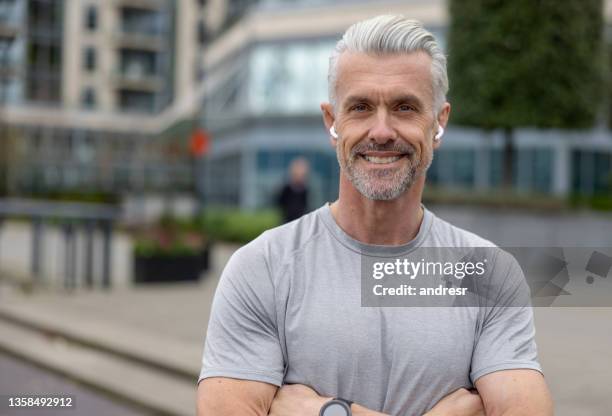 happy man running outdoors listening to music - 40 year old male models stock pictures, royalty-free photos & images