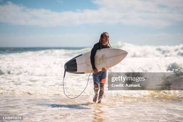 männlicher surfer kommt am tallebudgera beach aus dem wasser - athletics australia stock-fotos und bilder