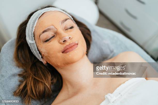 beautiful young woman at beauty clinic - gezichtsbehandeling stockfoto's en -beelden
