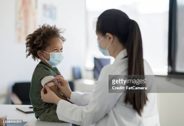 ottenere una benda dopo un vaccino - doctor with child foto e immagini stock