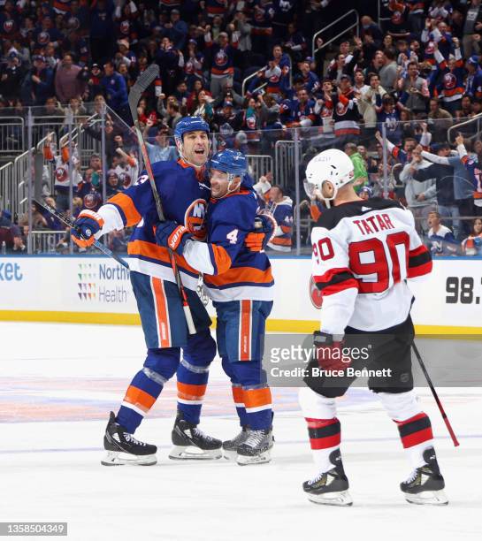 Andy Greene of the New York Islanders celebrates his second period goal against the New Jersey Devils and is joined by Zdeno Chara at the UBS Arena...