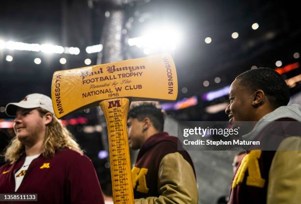 Members of the University of Minnesota football team carry the Paul Bunyan axe trophy on the field before the game between the Pittsburgh Steelers...