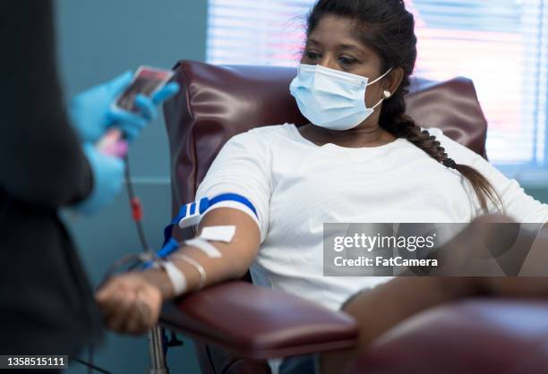 nurse hooking up a woman for blood donation - blood donation stock pictures, royalty-free photos & images