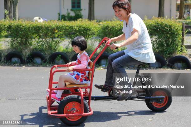 mother and child riding together on a three wheeled cycle . spring season activities - filipino tricycle stock pictures, royalty-free photos & images
