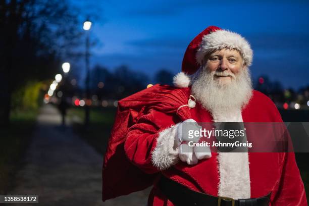 cheerful outdoor portrait of father christmas with presents - claus lange stock pictures, royalty-free photos & images