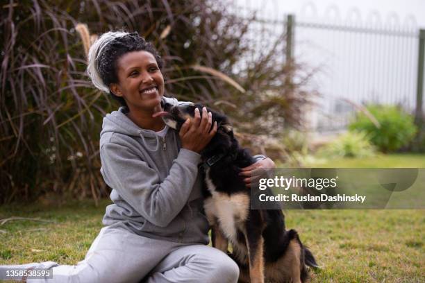 woman playing with dog outdoors. - israeli woman stock pictures, royalty-free photos & images