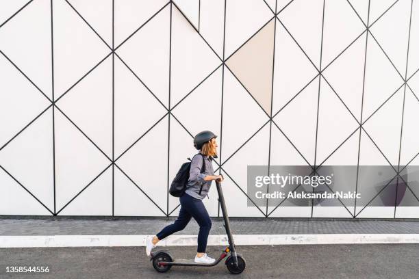 viaje al trabajo en un scooter eléctrico - riding scooter fotografías e imágenes de stock