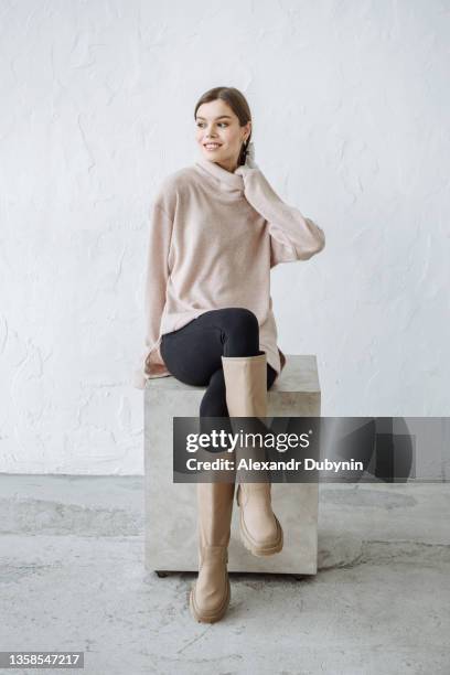 woman model happy sitting in a new collection of warm winter clothes sweater - hot female models stock pictures, royalty-free photos & images