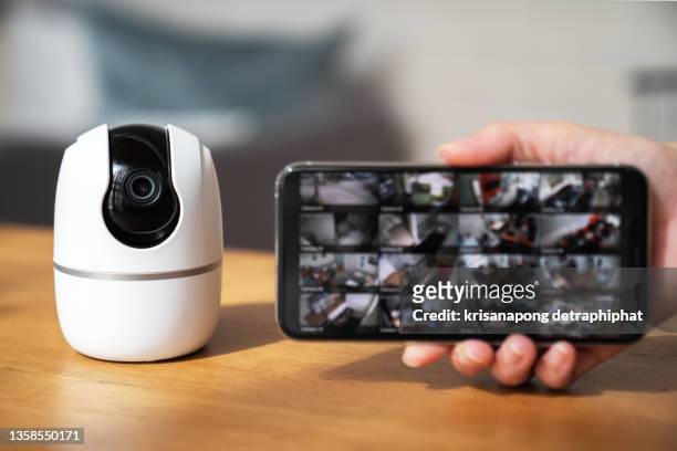 close up hand presses the phone on the surveillance camera. - surveillance camera - fotografias e filmes do acervo