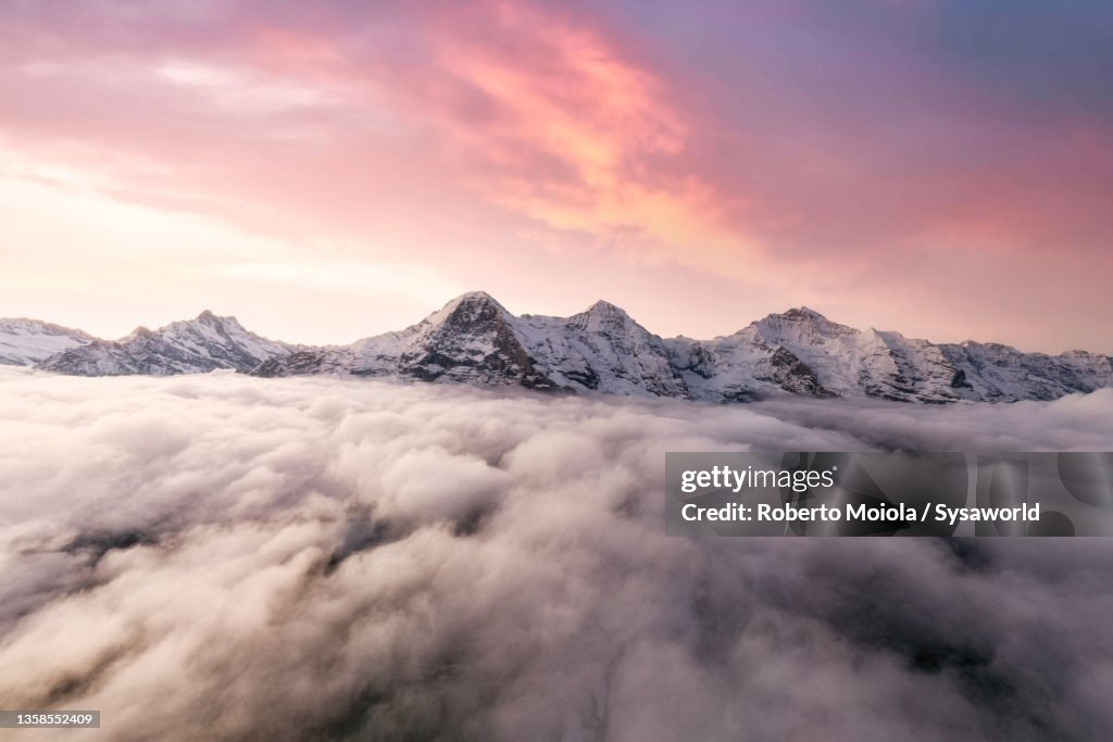 Aerial view of Eiger and Monch peaks in fog at dawn, Switzerland