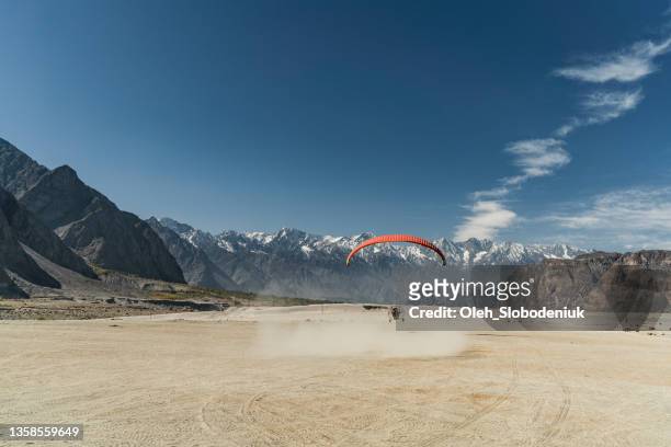 paramotor flying over katpana desert in northern pakistan - gilgit stock pictures, royalty-free photos & images
