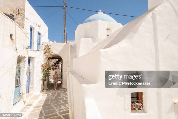 young woman strolling in the narrow greek alleys - ios greece stock pictures, royalty-free photos & images