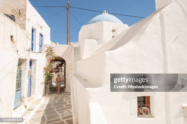 young woman strolling in the narrow greek alleys - ios grécia imagens e fotografias de stock