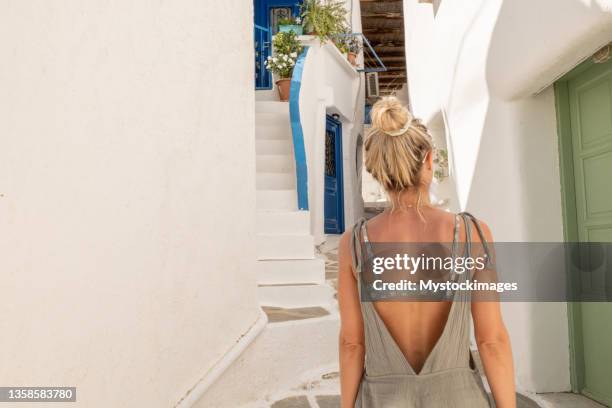 young woman strolling in the narrow greek alleys - ios greece stock pictures, royalty-free photos & images