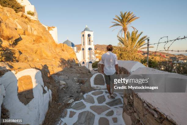 young man strolling in the narrow greek alleys - ios greece stock pictures, royalty-free photos & images