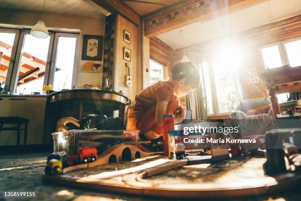 boy playing with train set at home. - ludoteca foto e immagini stock