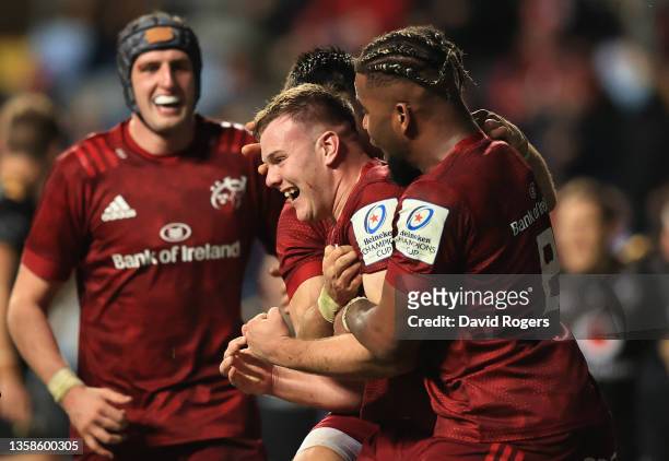 Scott Buckley of Munster celebrates after scoring their sides fourth try with team mate Daniel Okeke during the Heineken Champions Cup match between...