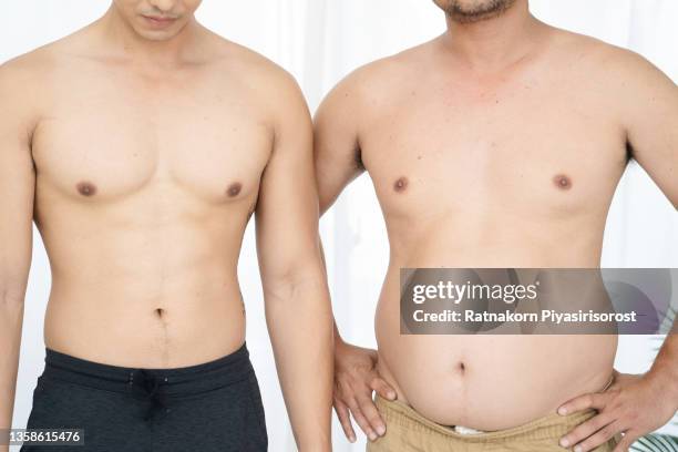 two naked men comparing belly fat and slim six pack - asian six pack photos et images de collection