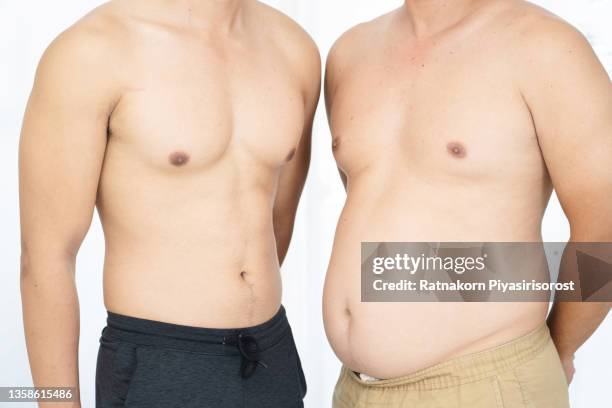 two naked men comparing belly fat and slim six pack - fat loss training stockfoto's en -beelden