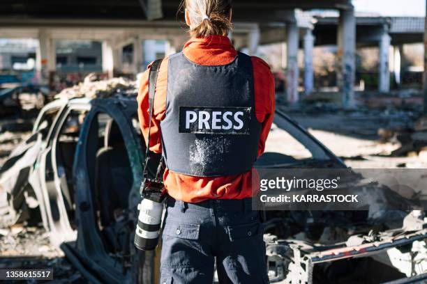 one man, war journalist with digital camera at the place of action, in war zone. - bullet proof vest stock pictures, royalty-free photos & images