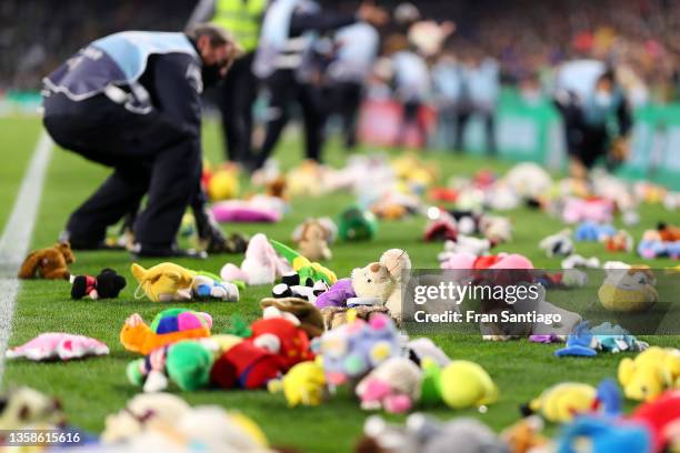 Fans of Real Betis throw stuffed animals and toys on to the pitch for charity which will be collected and given to children after the game during the...