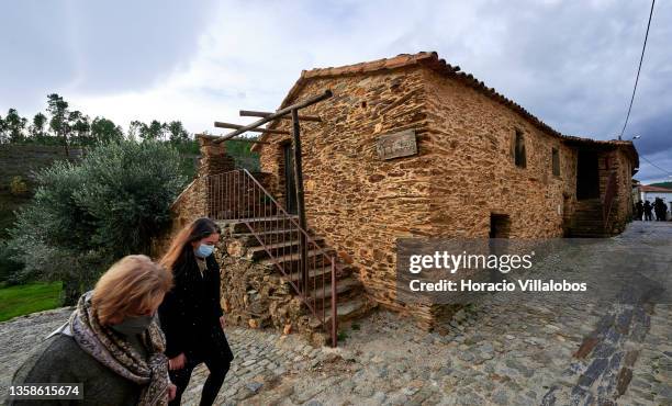 Short-term rental establishment "Xisto Sentido” owner Fernanda Custodio and a staffer wear protective masks as they walk outside the premises in this...