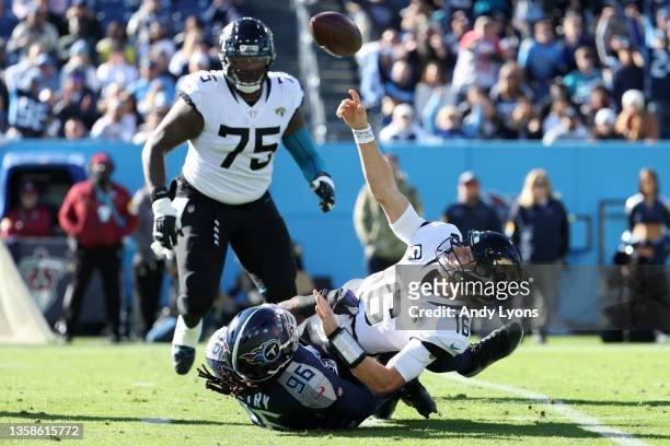 Trevor Lawrence of the Jacksonville Jaguars throws under pressure from Denico Autry of the Tennessee Titans during the first quarter at Nissan...