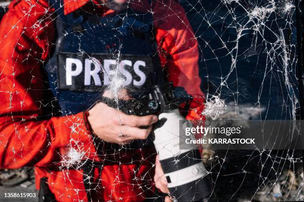 one man, war journalist with digital camera at the place of action, in war zone. - periodismo fotografías e imágenes de stock