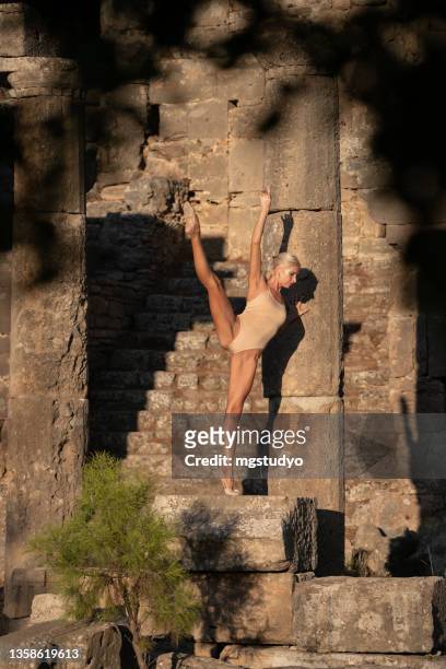 moderne balletttänzerin, die den split in einer alten ruine macht. - spagat stock-fotos und bilder
