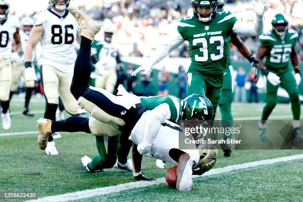 Alvin Kamara of the New Orleans Saints scores on a rushing touchdown against Ashtyn Davis of the New York Jets in the second quarter at MetLife...