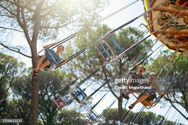 kids enjoying chair swing ride - italian carnival stock pictures, royalty-free photos & images