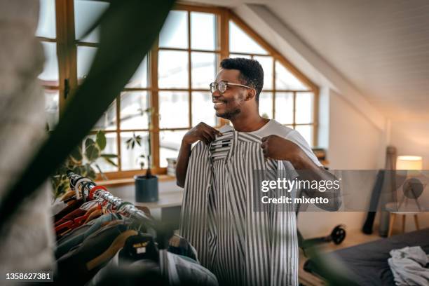 homme choisissant des vêtements à partir d’un rack à la maison - choose photos et images de collection