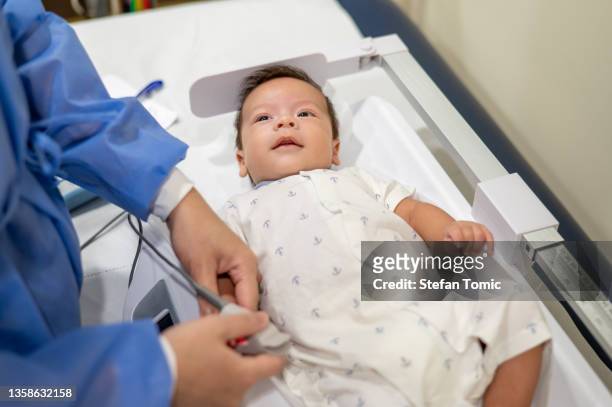 einnahme von vitalzeichen während einer routinemäßigen medizinischen untersuchung eines neugeborenen in einem krankenhaus - arabian baby stock-fotos und bilder