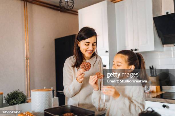 maman et sa fille font des gâteaux dans sa cuisine - goûter photos et images de collection