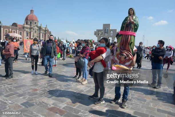People arrive the Basilica de Guadalupe with a giant figure of the Virgin of Guadalupe as part of the Day of Our Lady of Guadalupe Celebrations on...