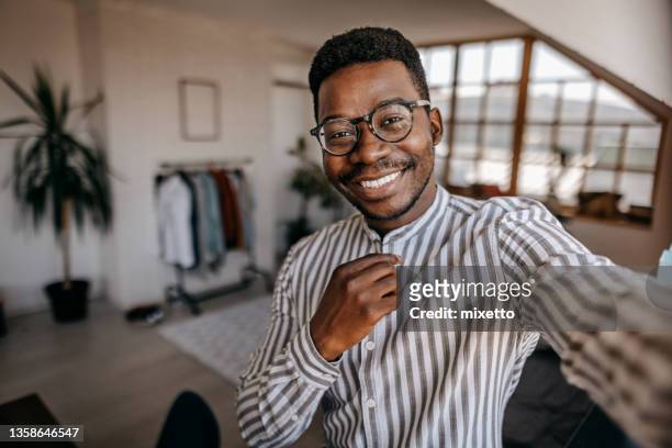 fröhlicher junger mann macht selfie zu hause - menswear stock-fotos und bilder