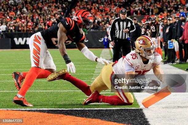 George Kittle of the San Francisco 49ers rushes for a fourteen-yard touchdown over Chidobe Awuzie of the Cincinnati Bengals in the second quarter of...