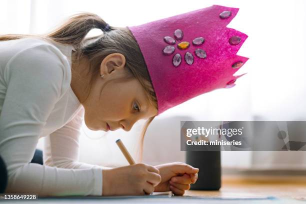kleines mädchen malt mit buntstiften in einem wohnzimmer - kinder malen boden stock-fotos und bilder