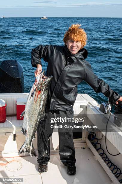 excited young fisherman with the first salmon he has ever caught. haida gwaii (queen charlotte islands), graham island, british columbia, canada. - chinook stock pictures, royalty-free photos & images