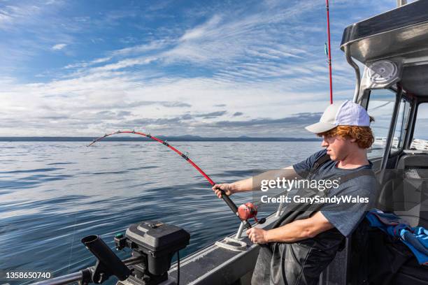 adolescente che combatte con un grande salmone chinook (salmone reale). - fishing reel foto e immagini stock